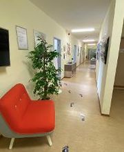 Eine Couch und eine Pflanze in einem langen Gang.