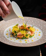 Gourmet dish being artfully plated at L’Atelier Robuchon, emphasizing culinary precision and luxury presentation.