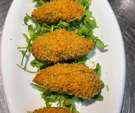 Knusprige panierte Tapas auf Rucola. "Croquetas".