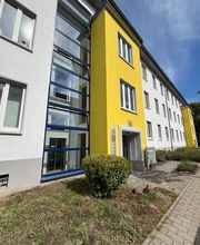 Außenansicht vom Gebäude der Einrichtung. Gelb, weiße Fassade. Sonniger Tag. 