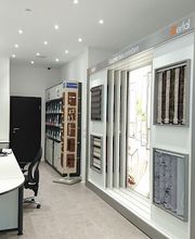 Ein Innenbereich eines Showrooms mit verschiedenen Sonnenschutzlösungen wie Rollos, Plissees und Jalousien.