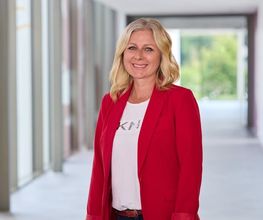 Die pflegerische Departmentleitung der Tagesklinik Anna in Neuss steht im Flur und blickt in die Kamera