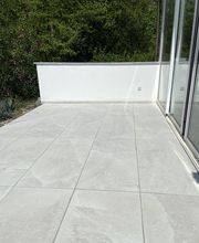 Edle Keramiksteine auf stabiler Betongrundlage und eine frisch verputzte Wand - für eine moderne und gepflegte Terrassengestaltung