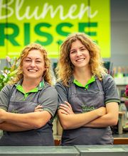 Blumen-Risse Team in der Floristik steht am Tresen vor Logo im Blumenmarkt Lüdinghausen