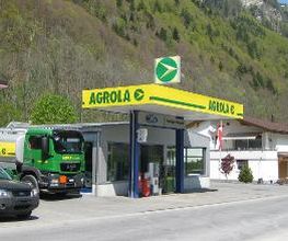 AGROLA Tankstelle in Linthal, LAVEBA Genossenschaft, bei Ford Garage. Im Hintergrund Waldhang. Eine Tanksäule überdacht mit Zahlterminal