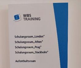 Plakat mit Auflistung der Räume (Schulungsraum London, ...)