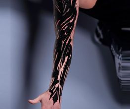 Blastover Sleeve auf dem Arm. Abstrakte schwarze Elemente wurden genutzt um die alte Tätowierung in den Hintergrund treten zu lassen.