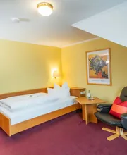 Einzelzimmer
Wer allein reist, muss nicht auf Komfort verzichten. Unsere Einzelzimmer sind gemütlich eingerichtet und bieten alles, was Sie für eine entspannte Auszeit brauchen. Ein klarer Kopf beginnt in einem klaren Raum.