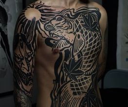 Blackwork-Frontpiece eines Koi-Fisches mit Blättern über Brust und Schulter.