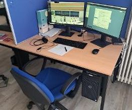 Arbeitsplatz mit 2 Bildschirmen, einem Bürostuhl, Tastatur, Maus und Headset.