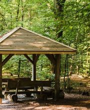 Eine überdachte Sitzgruppe im FriedWald Buxtehude bietet Besuchern Schutz.