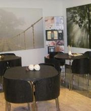 Aufenthaltsraum mit mehreren Tischen und Stühlen.