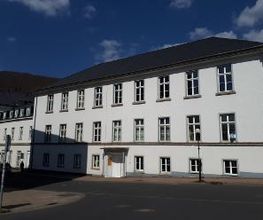 ein weißes Gebäude mit zwei Stockwerken.