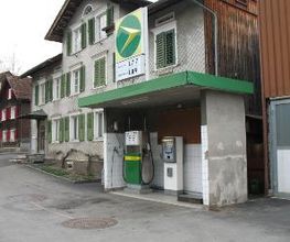 AGROLA Tankstelle in Grabs. Kleine Überdachung. Eine Tanksäule. Grosses AGROLA Logo auf Dach. Dahinter ein Wohhaus