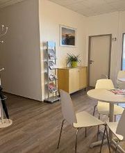 Aufenthaltsbereich mit Bücherregal runden tischen und Sitzgelegenheiten