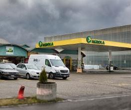 AGROLA Tankstelle in Kölliken; grosse überdachte Tankstelle; dahinter liegt ein TopShop und links daneben eine Landi; bewölkte Stimmung am Himmel
