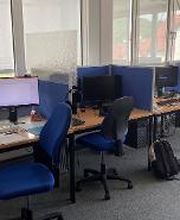 4 Arbeitsplätze direkt am Fenster mit jeweils 2 Bildschirmen, einem Bürostuhl, Tastatur, Maus und Headset. 