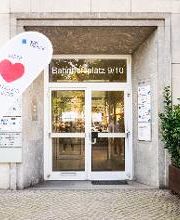 Eingangstür von außen mit Fahnenständer auf dem ein großes rotes Herz und die Aufschrift unser Herz schlägt für Bildung zu sehen ist.