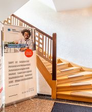Eingangsbereich Treppenhaus mit Werbeaufsteller.