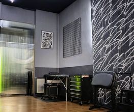 OMEN Lab Tattooraum mit moderner Graffiti-Wandgestaltung, bestehend aus abstrakten, weißen Linien.