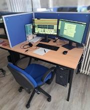 Arbeitsplatz mit 2 Bildschirmen, einem Bürostuhl, Tastatur, Maus und Headset. 