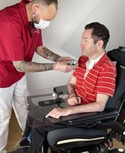 Casa Außerklinische Intensivpflege Mitarbeiter und Patient im Rollstuhl