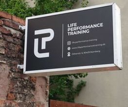 LIFE PERFORMANCE TRAINING | Personal Training Nürnberg - Nahaufnahme eines Studioschilds an der Außenwand eines privaten Gyms in Nürnberg. Ideal für Suchanfragen rund um Personal Training, privates Fitnessstudio und individuelle Trainingsbetreuung in zentraler Lage.
