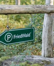 Schilder weisen den Weg zum kostenlosen Parkplatz am FriedWald.