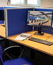 Arbeitsplatz mit zwei Bildschirmen, Tastatur und Maus sowie blaue Trennwände.