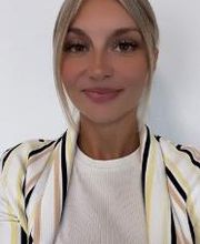 junge Frau mit blonden Haaren und gestreifter Jacke.