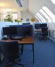 Arbeitsplätze mit zwei Bildschirmen Tastatur, Headset und MAus und dazugehöriges Lehrmaterial