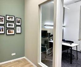 Blick in einen Hörraum - links Bilder von der Historie des Unternehmens
