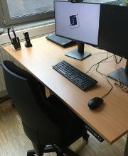 ein PC Arbeitsplatz mit 2 Bildschirmen, einem Bürostuhl, einer Tastatur und einer Maus.