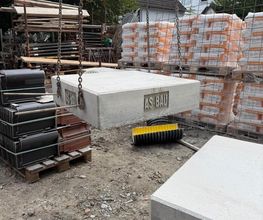 Betonfertigteil mit AS-BAU Prägung hängt am Kran. Betonarbeiten im Rohbau vom Meisterbetrieb AS-Bau.