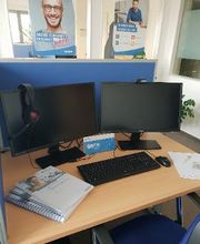 Arbeitsplatz für Teilnehmer mit zwei Bildschirmen Tastatur und Maus, dazu noch ein paar Unterlagen zum lernen