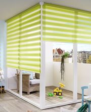 Ein liebevoll eingerichtetes Kinderzimmer mit grünen Doppelrollos, die sowohl Lichtdurchlässigkeit als auch Verdunkelung ermöglichen.