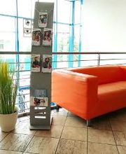 Empfangsbereich WBS TRAINING in Waren mit Couch und Werbeaufsteller.