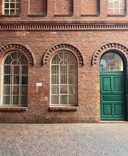 Backsteingebäude mit grüner Eingangstür.