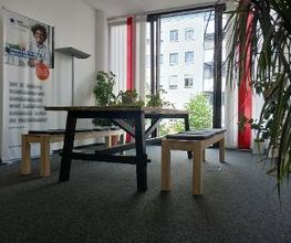 Zwei Sitzbänke an einem Tisch vor einem Fenster