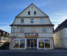 Academy Fahrschule Baumann - Stuttgart Vaihingen - Außenansicht einer Fahrschule in Stuttgart-Vaihingen mit großer Fensterfront, zentraler Lage und gut sichtbarem Eingang für Fahrschüler und Besucher.