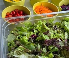dean&david Catering | Karlsruhe - Salatbar mit Blattsalat, Tomaten, Mango, Paprika, Karotten, Gurken, Erbsen und Brot als frische Buffetstation für Catering Events.