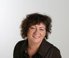 Eine Frau mit dunklen Haaren und dunkler Bluse.