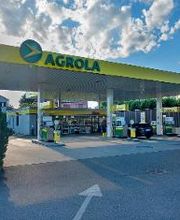 AGROLA Tankstelle in Arbon mit LAVEBA Shop. Im Vordergrund Einfahrt mit Pfeil. Links Totem mit AGROLA Logo, digitaler Preisanzeige und rotem Shop Logo