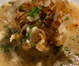 Geschlossene Gesellschaft Nahaufnahme einer edlen Suppe mit knusprigem Topping und frischen Kräutern – Fine Dining bei Geschlossene Gesellschaft von Wulf Mey.