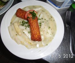 Gefüllte Kartoffeltaschen mit Frischkäse gefüllt auf frischem Spargelgemüse