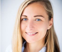 Portrait einer Frau mit langen blonden Haaren.