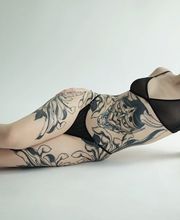 Asiatische Hannya Maske auf dem Bauch, auf den Hüften große Chrysanthemen. Sehr großes Tattoo, ästhetisch und feminin auf dem Körper angebracht