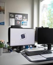 Arbeitsplatz mit 2 Bildschirmen. Auf einem Bildschirm ist das WBS Logo zu sehen.