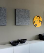 Eine Wand mit niedrigen Schränken und Bildern an der Wand.