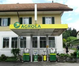 AGROLA Tankstelle in Walkringen, zwei Tanksäulen und ein Zahlterminal überdacht, im Hintergrund Wohnhaus mit mehreren Fenstern, frontale Aufnahme